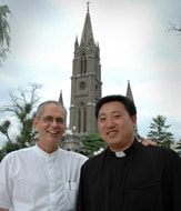 Fr. Brian Barrrons in front of the Jilin cathedral with Fr. Jin